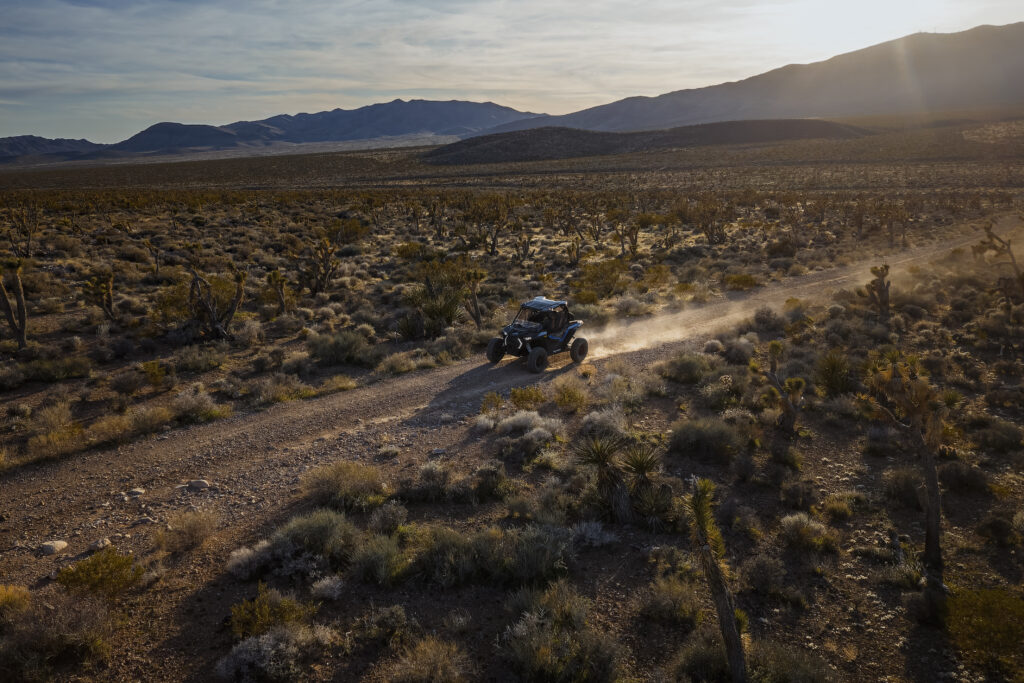 Mojave Desert Landscape: 10 Amazing Features to Notice 2 Mojave Desert landscape with mountain ridges, shrubs and an RZR on a trail