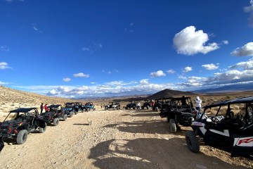 a group of people on a motorcycle in the desert