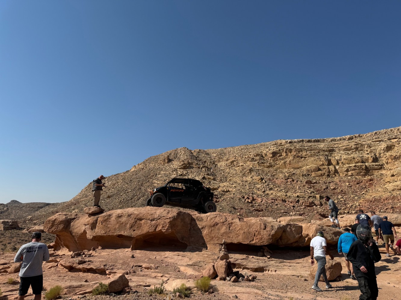 a group of people standing on a rocky hill